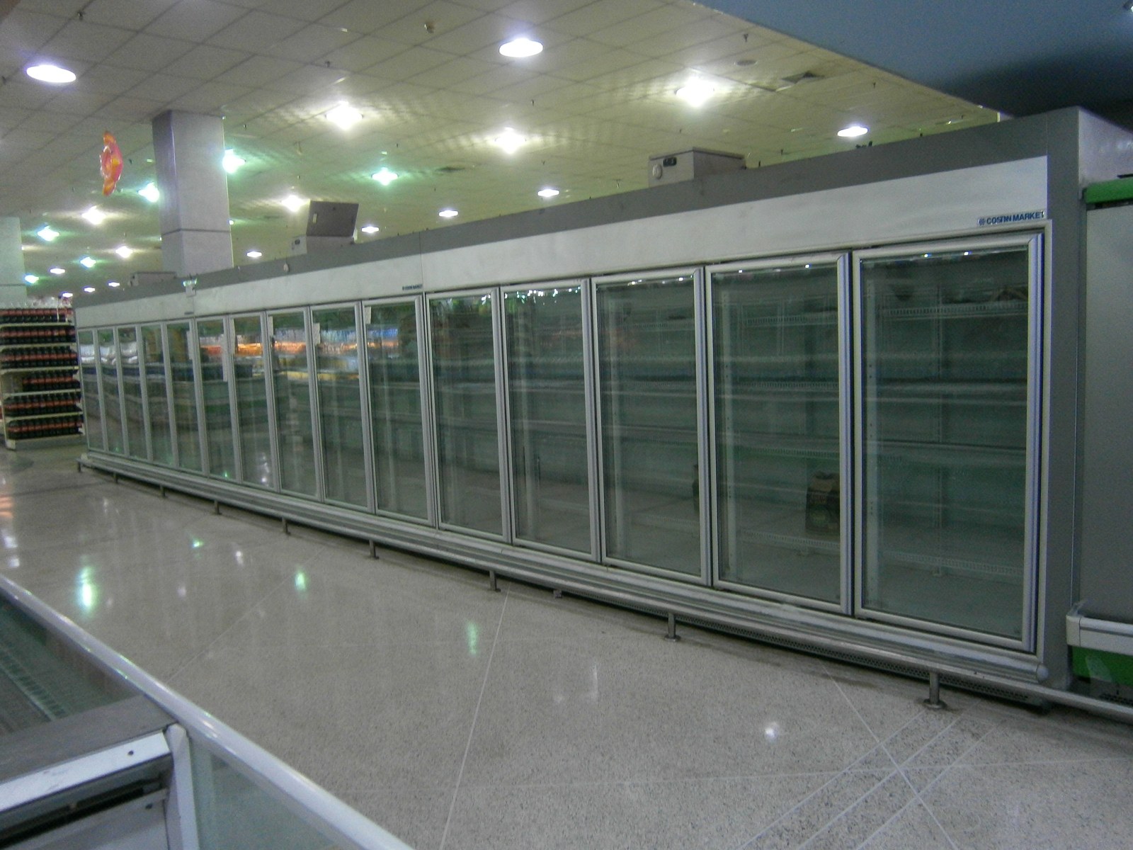 Rows of empty refrigerated display cases in a supermarket in Los Teques, Venezuela, during shortages in 2014