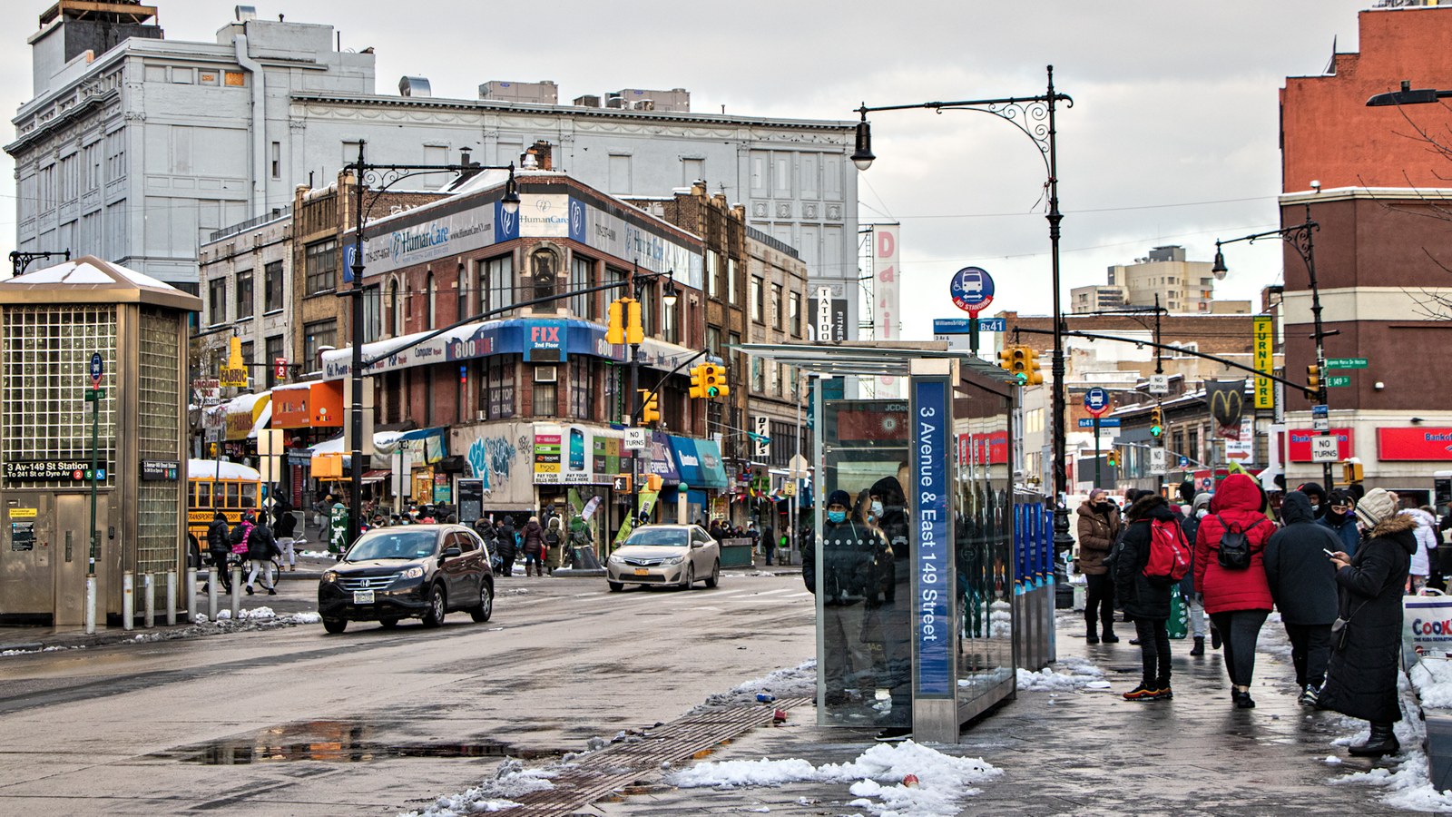 Pedestrians and traffic at East 149th Street and Third Avenue, the Hub shopping district in the Bronx, on a winter day.